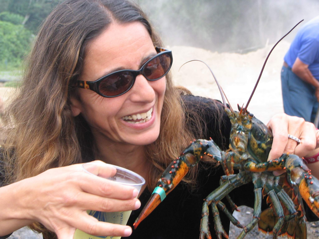 Photo of Adina Paytan holding a lobster in the field